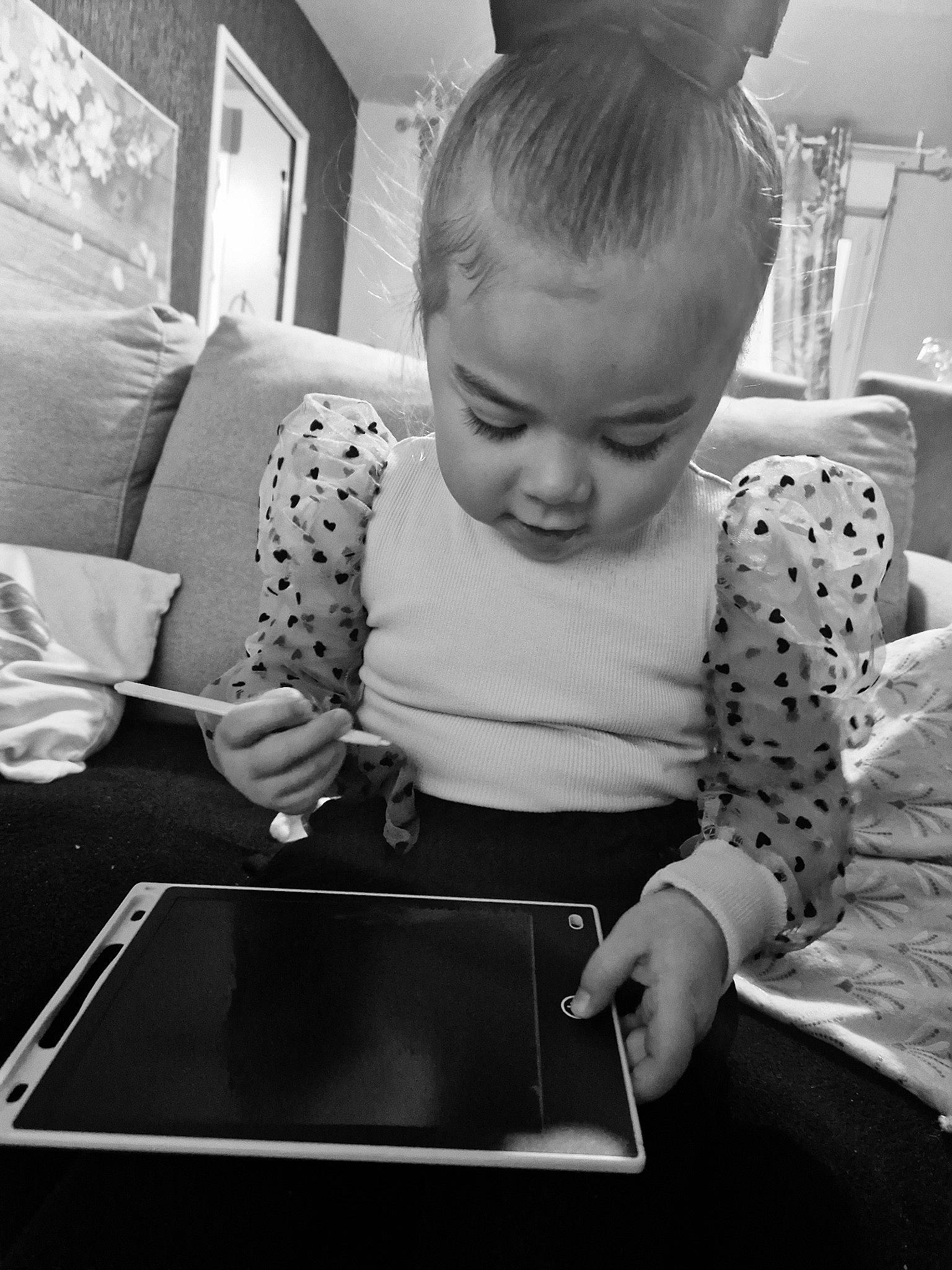 Lya participe au concours pour gagner de l'argent avec cette photo : baby, black, black_and_white, child, comfort, fun, gadget, happy, monochrome, monochrome_photography, person, photograph, play, room, sitting, standing, stock_photography, style, t_shirt, tablet_computer