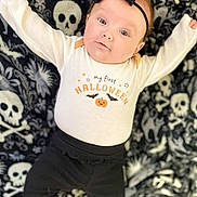 Allison joined the competition — help win amazing prizes! baby, infant, halloween, onesie, black_bow, headband, skull_pattern, blanket, cute, lying_down, black_pants, pumpkin, bats, holiday, celebration, child, costume, smiling, portrait, indoors