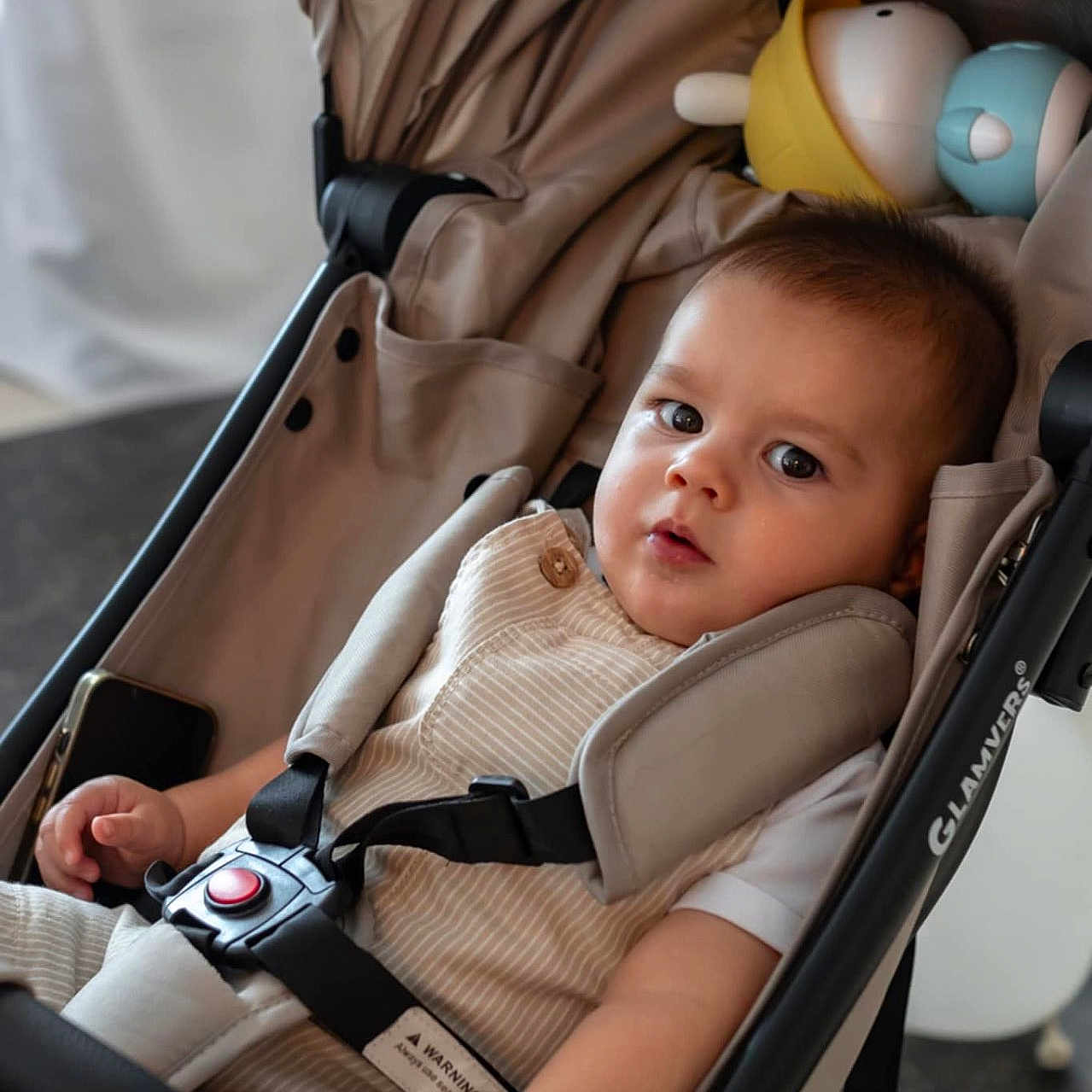 Turcan Artur participe au concours pour gagner de l'argent avec cette photo : baby, candid, child, clothing, comfortable, curious, cute, expression, face, hand, indoor, infant, person, portrait, safety, seatbelt, sitting, stroller, toy, young