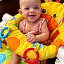 baby, smiling, child, giraffe, baby_seat, toys, colorful, happy, infant, cute, playful, indoors, clothing, face, person, seat, plastic, fabric, expression, sitting