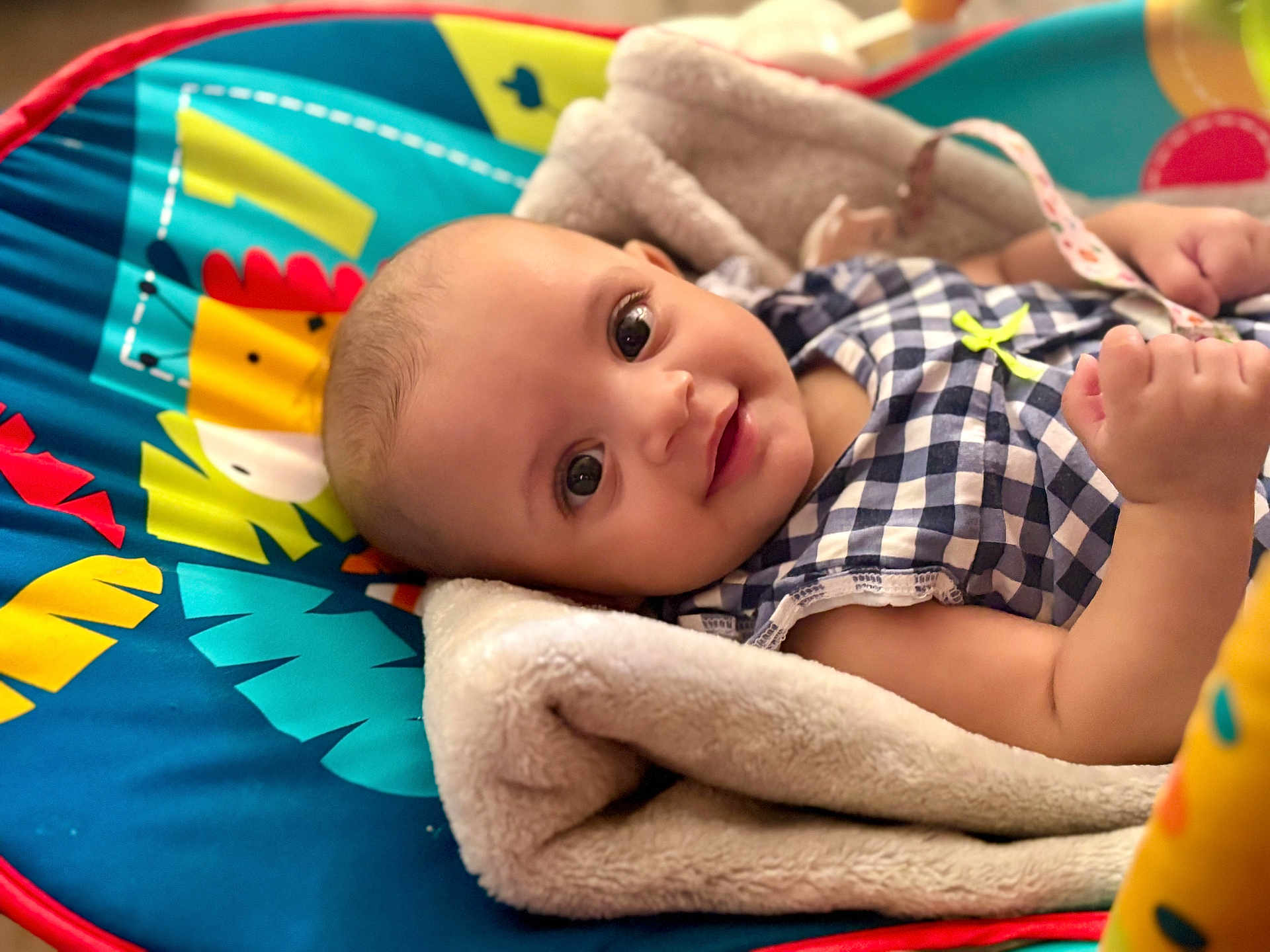 Ashley Saraev is registered to the contest to win money with this photo: baby, infant, blanket, play_mat, colorful, smiling, face, child, cute, clothing, portrait, soft_texture, indoors, happy, young, person, resting, cozy, bright, eyes