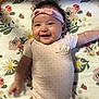Monica joined the competition — help win amazing prizes! baby, smiling, infant, headband, onesie, pink, polka_dot, blanket, floral_pattern, cute, happy, lying_down, child, adorable, face, person, soft_lighting, indoor, playpen, baby_toy