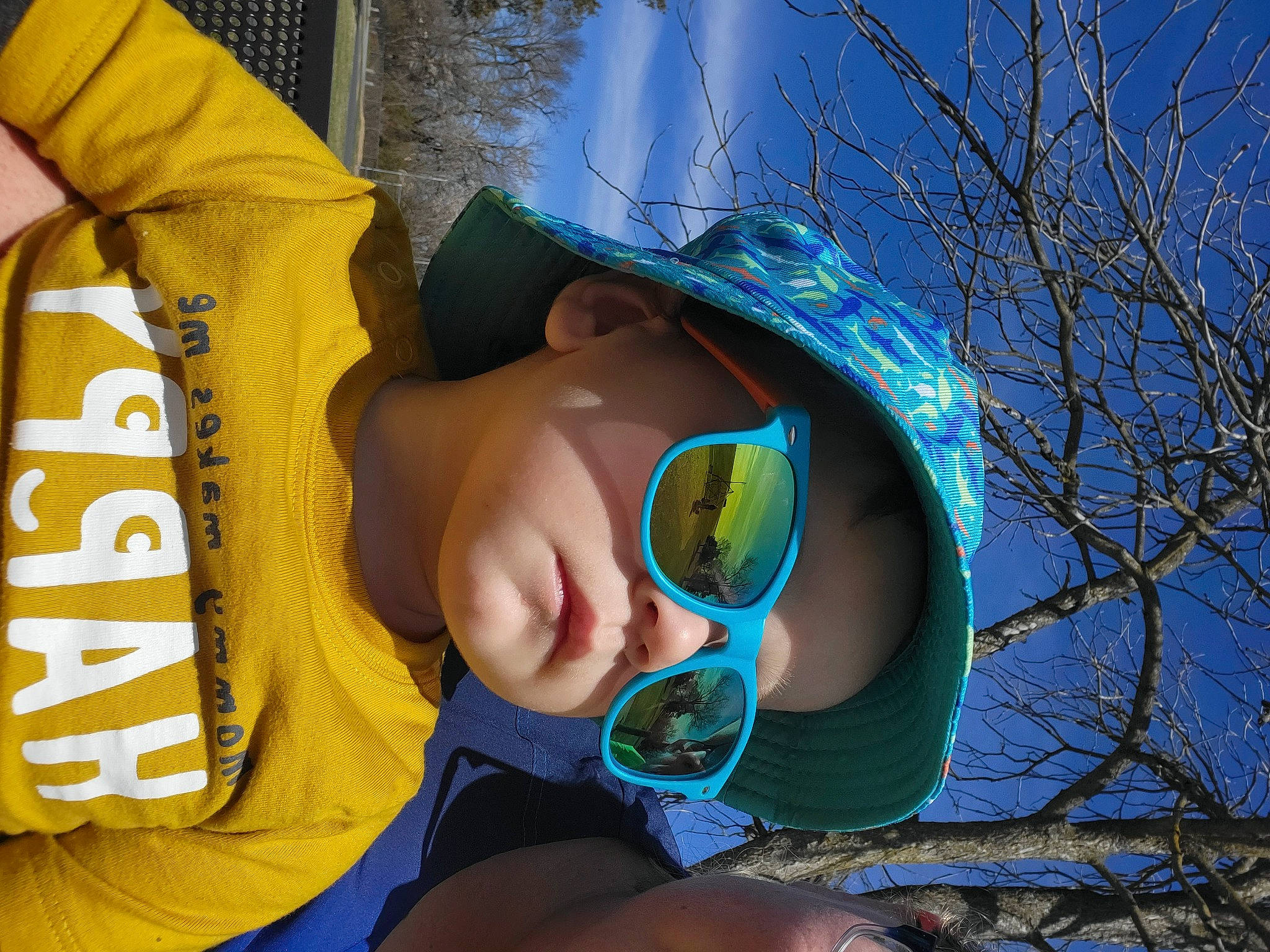 Robbie joined the competition — help win amazing prizes! baseball_cap, cap, cool, eyewear, finger, fun, glasses, goggles, grass, happy, hat, headgear, leaf, person, personal_protective_equipment, sky, sun_hat, sunglasses, toddler, vision_care