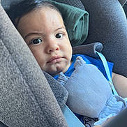Isaac a rejoint le concours — aidez-le/la à gagner de superbes lots ! toddler, child, car_seat, plush_toy, blue_clothing, seat_belt, indoors, portrait, face, expression, young_child, seat, safety, soft_toy, curly_hair, close_up, baby, resting, cozy, candid