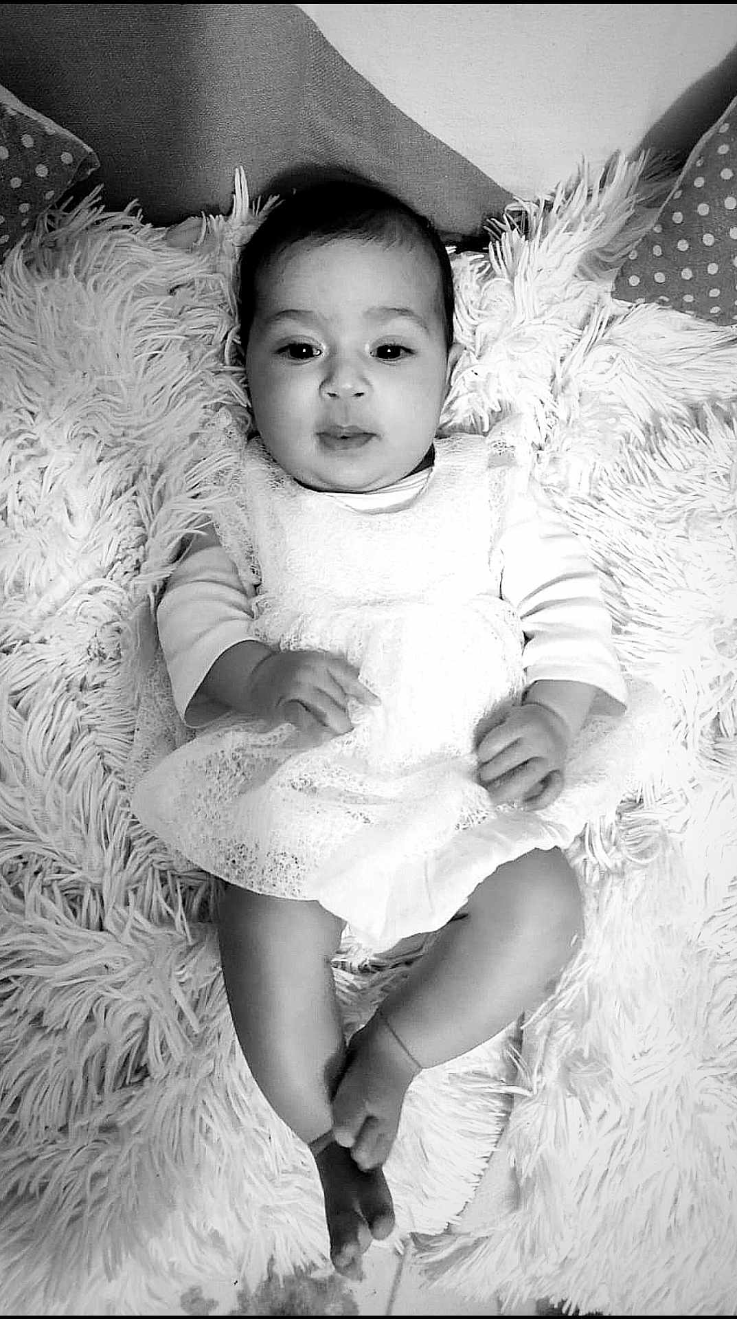 Arinasse participe au concours pour gagner de l'argent avec cette photo : baby, infant, child, dress, white_dress, lace, fluffy_rug, carpet, barefoot, indoor, portrait, cute, young_child, sitting, hands, feet, face, looking, monochrome, black_and_white