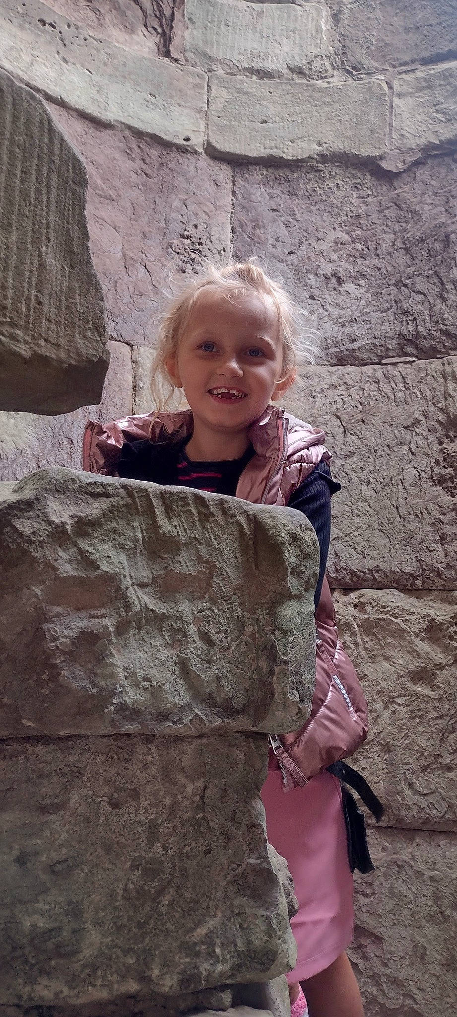 Darcie joined the competition — help win amazing prizes! bedrock, child, chin, concrete, face, fun, geology, hair, happy, head, joy, leisure, person, rock, sitting, skin, smile, soil, stone_wall, toddler