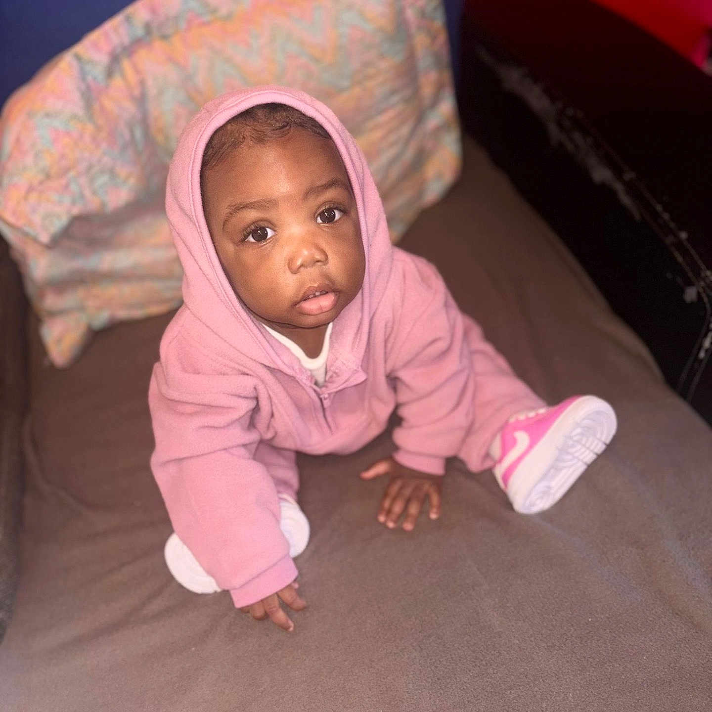 Névaly participe au concours pour gagner de l'argent avec cette photo : baby, bed, blanket, child, clothing, cozy, curious, cute, expression, face, footwear, hood, indoor, person, pink_hoodie, shoes, sitting, soft_texture, toddler, young_child