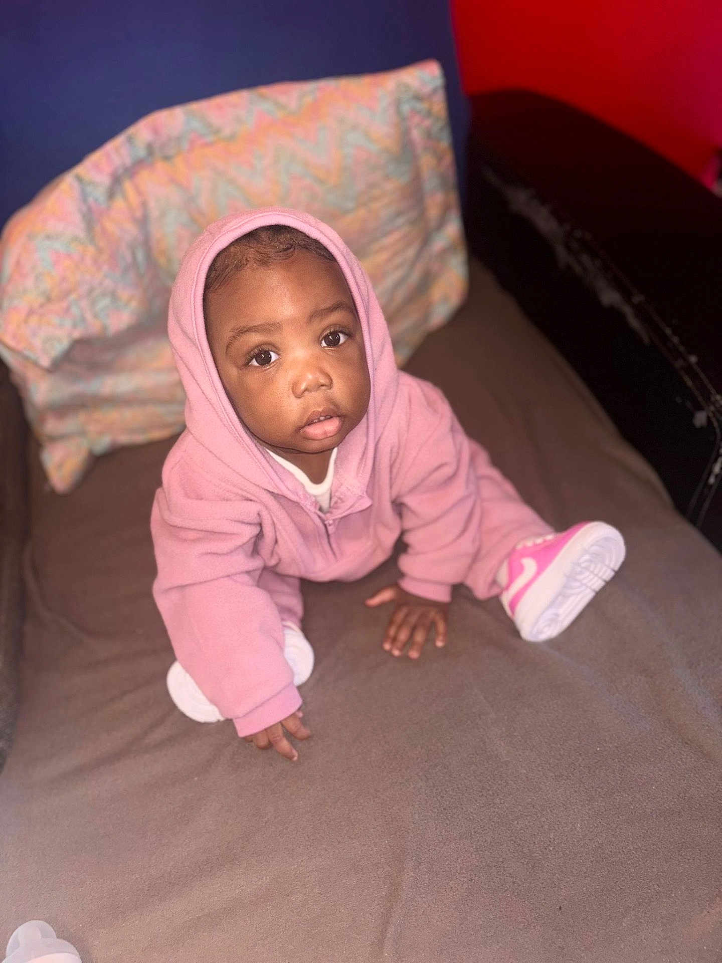 Névaly participe au concours pour gagner de l'argent avec cette photo : baby, bed, blanket, child, clothing, cozy, curious, cute, expression, face, footwear, hood, indoor, person, pink_hoodie, shoes, sitting, soft_texture, toddler, young_child