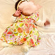Névaly participe au concours pour gagner de l'argent avec cette photo : baby, infant, child, dress, headband, bow, fruit_pattern, colorful, white_background, soft_surface, lying_down, motion_blur, hand, footwear, socks, cute, indoors, clothing, fabric, portrait