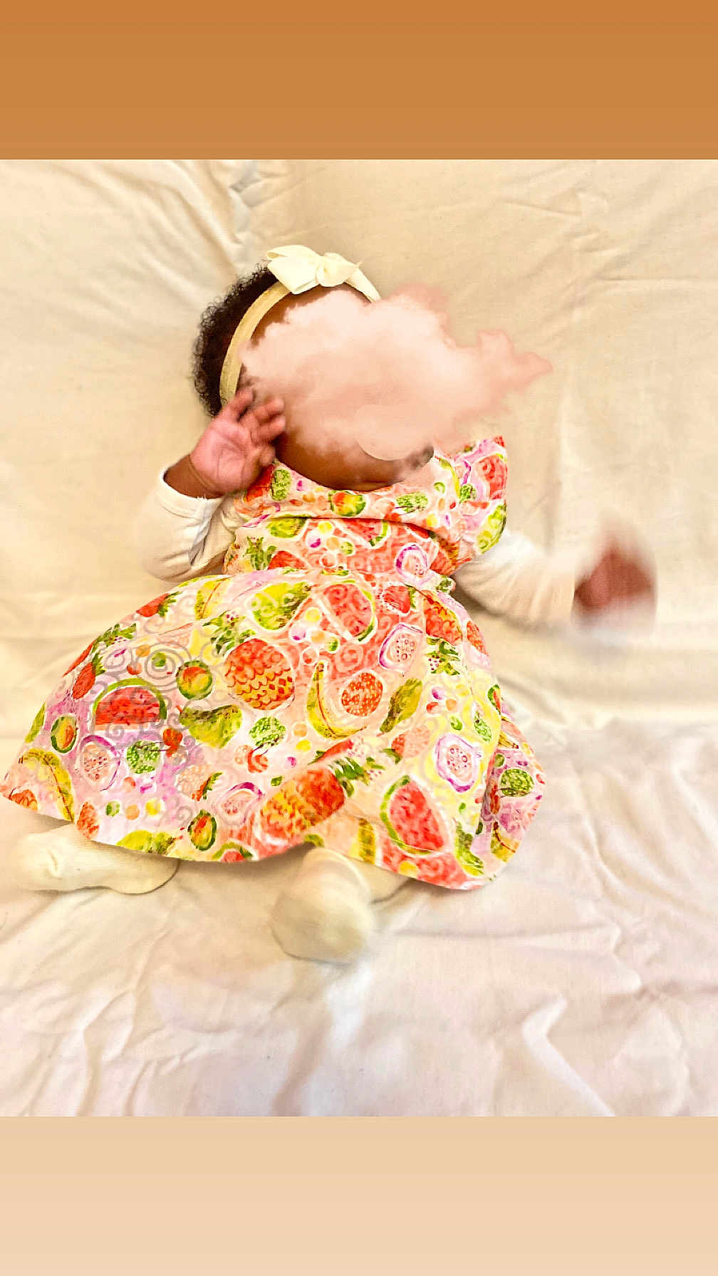 Névaly participe au concours pour gagner de l'argent avec cette photo : baby, infant, child, dress, headband, bow, fruit_pattern, colorful, white_background, soft_surface, lying_down, motion_blur, hand, footwear, socks, cute, indoors, clothing, fabric, portrait