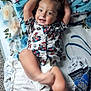 Octavian is registered to the contest to win money with this photo: bed, blanket, carpet, child, clothing, colorful, cozy, cute, diaper, foot, happy, indoors, mario, pattern, person, pillow, relaxing, sleeping_area, smiling, toddler