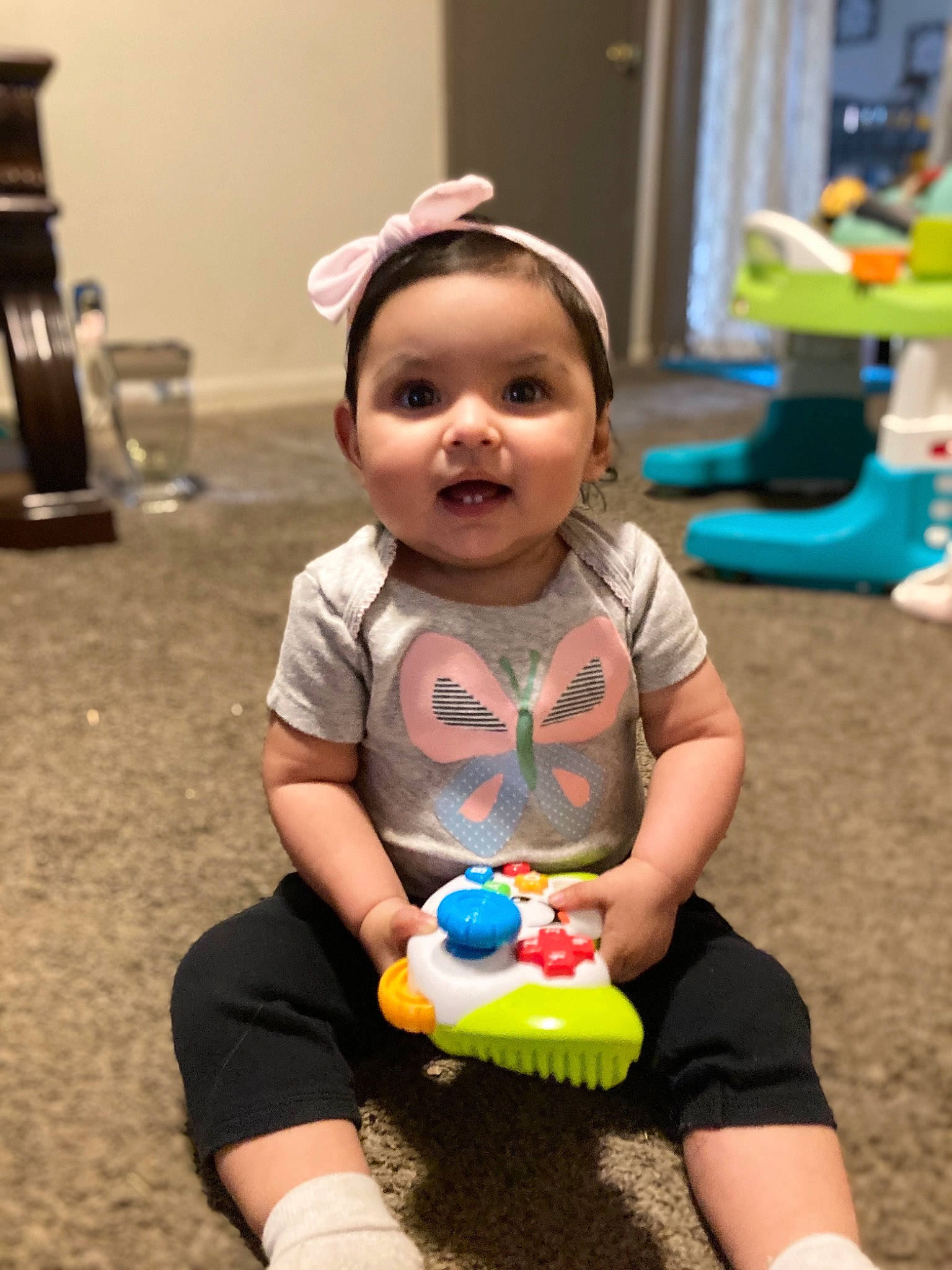 Paisley is registered to the contest to win money with this photo: baby, baby_playing_with_toys, baby_toddler_clothing, child, event, flooring, fun, green, happy, leisure, people, person, photograph, sitting, skin, smile, snapshot, thigh, toddler, toy