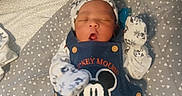 Amir is registered to the contest to win money with this photo: baby, baby_clothes, blanket, child, clothing, cozy, cute, hat, indoor, infant, lying_down, mickey_mouse, mittens, newborn, overalls, patterned_blanket, portrait, resting, sleeping, soft