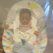 Amir joined the competition — help win amazing prizes! baby, baby_boy, baby_girl, baby_rocker, child, clothing, colorful, cute, floor, furniture, hoodie, indoor, infant, patterned, person, seat, socks, striped_shirt, wooden_floor, young_child