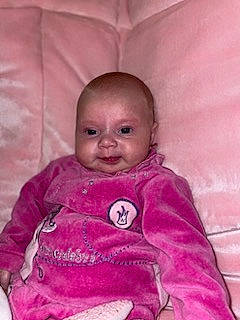 Maëlya a rejoint le concours — aidez-le/la à gagner de superbes lots ! baby, baby_products, baby_toddler_clothing, bedding, cheek, child, comfort, happy, iris, linens, magenta, nose, person, pink, purple, room, sitting, skin, sleeve, smile