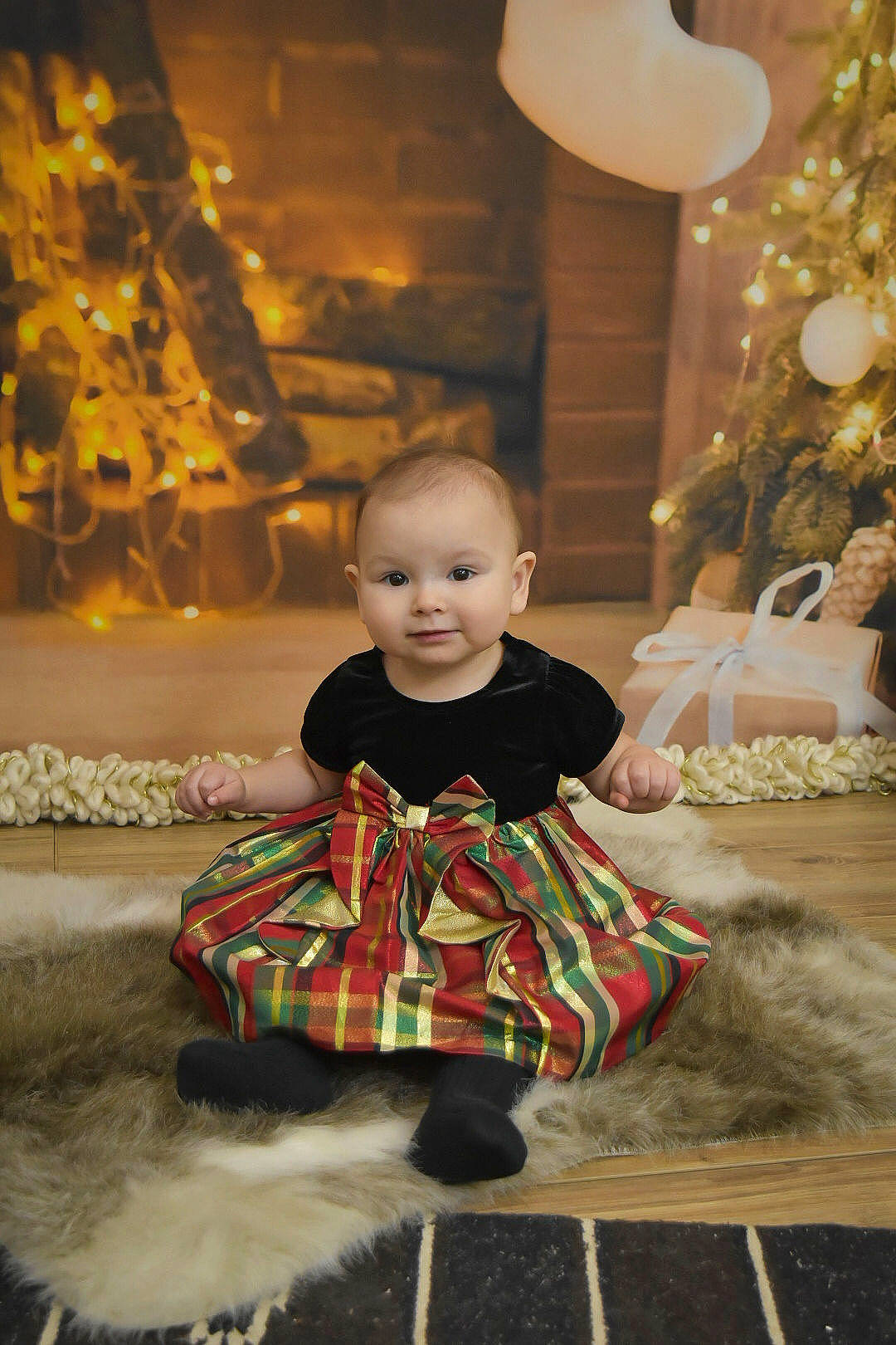 Zyra is registered to the contest to win money with this photo: baby, baby_toddler_clothing, child, dress, event, fashion, flash_photography, flooring, formal_wear, fun, happy, light, lighting, person, sitting, standing, tartan, toddler, tree, white
