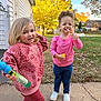 child, toddler, outdoor, play, bubble, toy, grass, sidewalk, sweatshirt, pink_clothing, blue_pants, white_shoes, happy, smiling, curly_hair, blond_hair, autumn, tree, house, fence