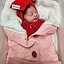 newborn, baby, sleeping, red_hat, red_outfit, pink_blanket, knitted_blanket, cozy, soft_texture, cushion, indoor, infant, peaceful, cute, portrait, wrapped, child, warm, resting, smiling