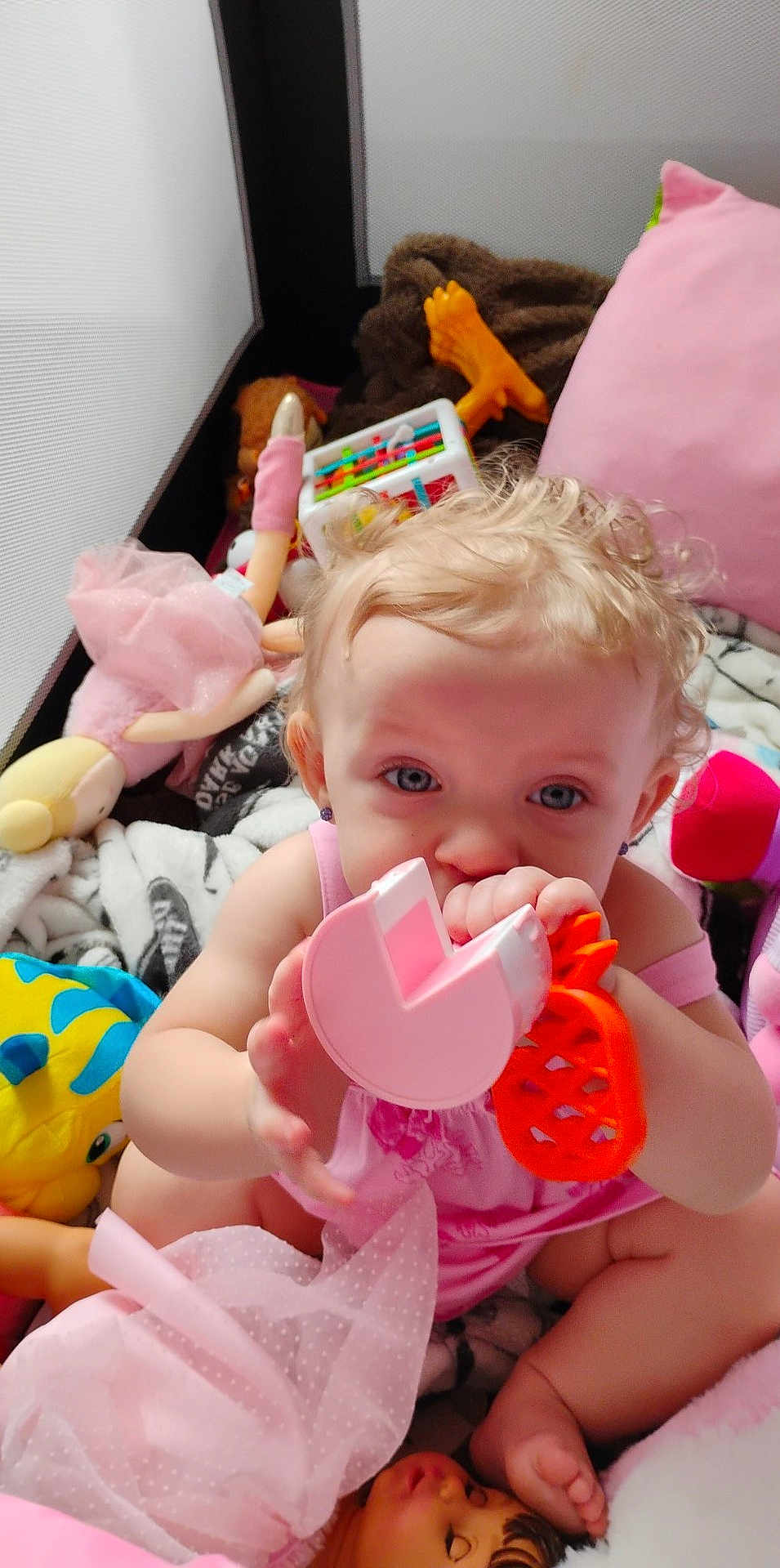 Daenerys Rhaenerya is registered to the contest to win money with this photo: baby, child, toys, doll, stuffed_animal, pink_clothing, teether, curly_hair, blue_eyes, indoor, play_area, blanket, soft_toys, cute, infant, sitting, colorful, closeup, playtime, fun