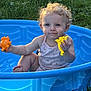 Daenerys joined the competition — help win amazing prizes! toddler, child, blue_pool, toy, yellow_toy, orange_toy, grass, outdoor, sunlight, curly_hair, sitting, summer, play, happy, baby, cute, plastic_pool, nature, person, water_play