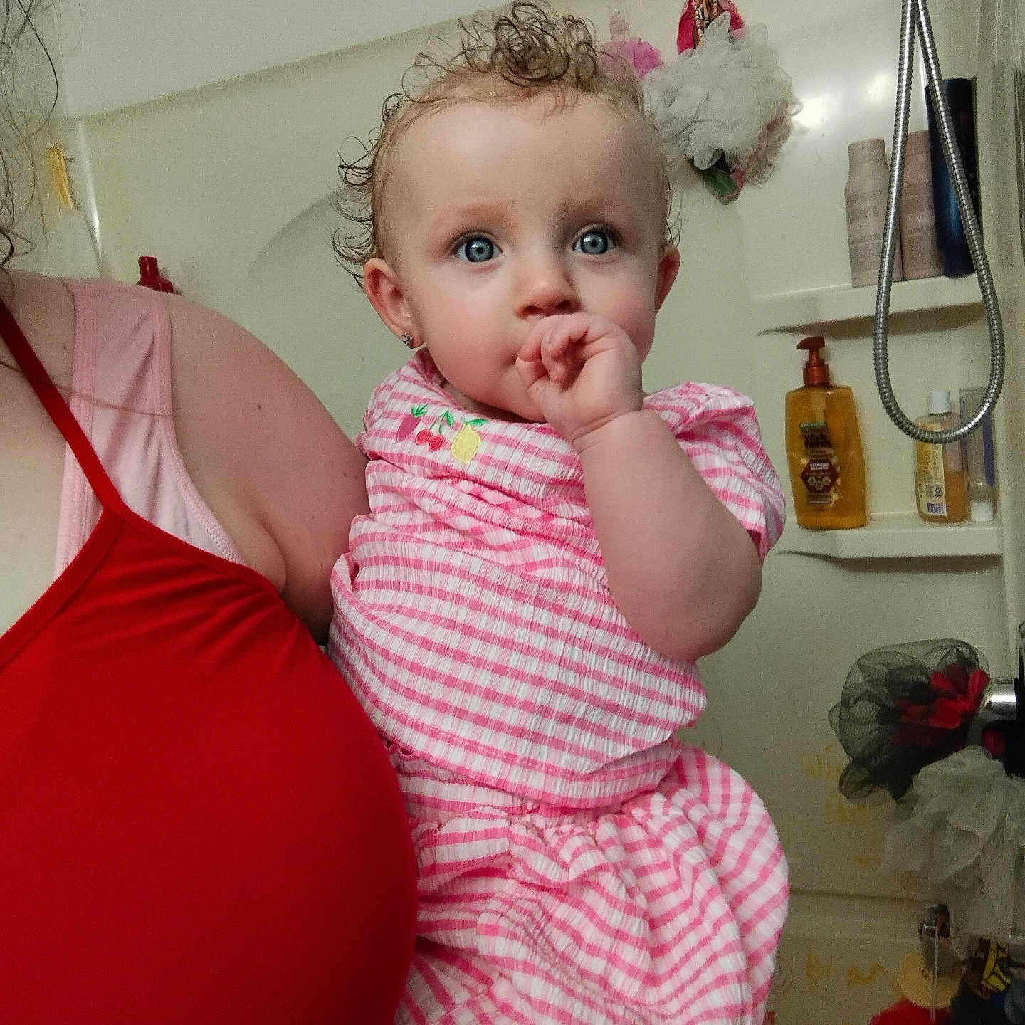 Daenerys is registered to the contest to win money with this photo: adult, baby, bathroom, blue_eyes, child, clothing, curious, curly_hair, cute, earrings, facial_expression, holding, human, indoor, person, pink_dress, portrait, shower, skin, thumb_sucking