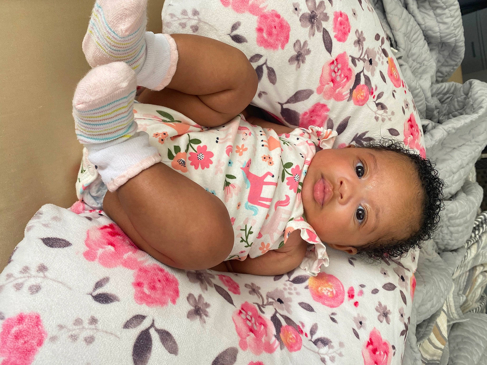 Nia is registered to the contest to win money with this photo: arm, baby, baby_toddler_clothing, comfort, eye, finger, hand, headgear, human_body, joint, linens, mouth, pattern, person, pink, skin, sleeve, sock, textile, thigh