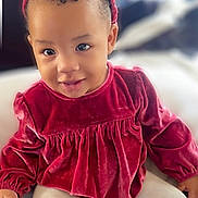 Heavenly is registered to the contest to win money with this photo: baby, blanket, bow, candid, child, cozy, cracker, cute, eyes, face, hand, headband, indoor, portrait, red_dress, sitting, smile, snack, toddler, velvet