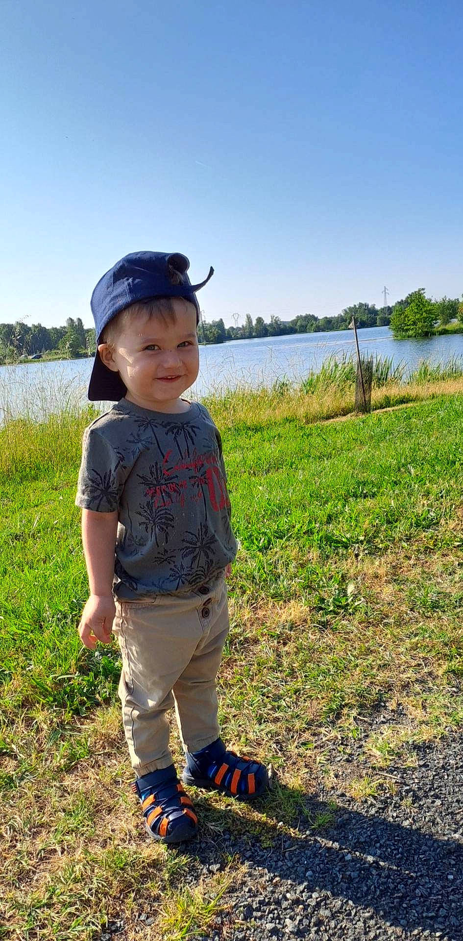 Wyatt participe au concours pour gagner de l'argent avec cette photo : baby_toddler_clothing, child, electric_blue, field, fun, grass, grassland, happy, hat, joy, lake, landscape, leisure, people_in_nature, person, plant, sky, soil, toddler, tree