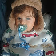Adam a rejoint le concours — aidez-le/la à gagner de superbes lots ! toddler, child, pacifier, hat, fur_hat, clothing, sitting, indoor, cute, face, blue_eyes, patterned_clothes, car_pattern, baby, comfort, infant, warm_clothing, portrait, young_child, cozy