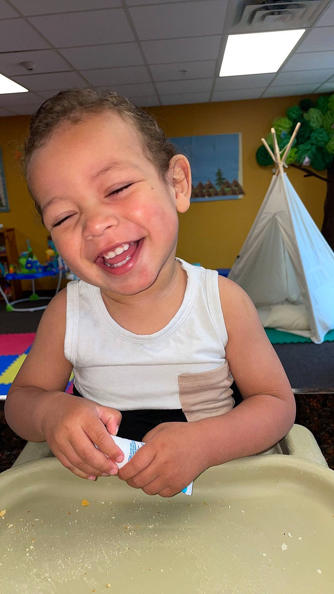 Cole is registered to the contest to win money with this photo: baby_toddler_clothing, chair, child, cooking, finger, fun, happy, joy, leisure, person, plant, play, room, sitting, skin, smile, summer, t_shirt, table, thumb