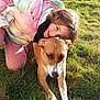 Vicky participe au concours pour gagner de l'argent avec cette photo : child, dog, grass, outdoor, sunlight, pet, playing, happy, nature, animal, casual_clothing, smiling, brown_dog, white_markings, pastel_jacket, friendship, bond, daylight, cute, fun