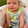 baby, child, infant, smile, face, striped_clothing, sunglasses, seat, cushion, bear_pattern, green_background, outdoor, cute, happy, portrait, person, summer, sunny, casual, playful