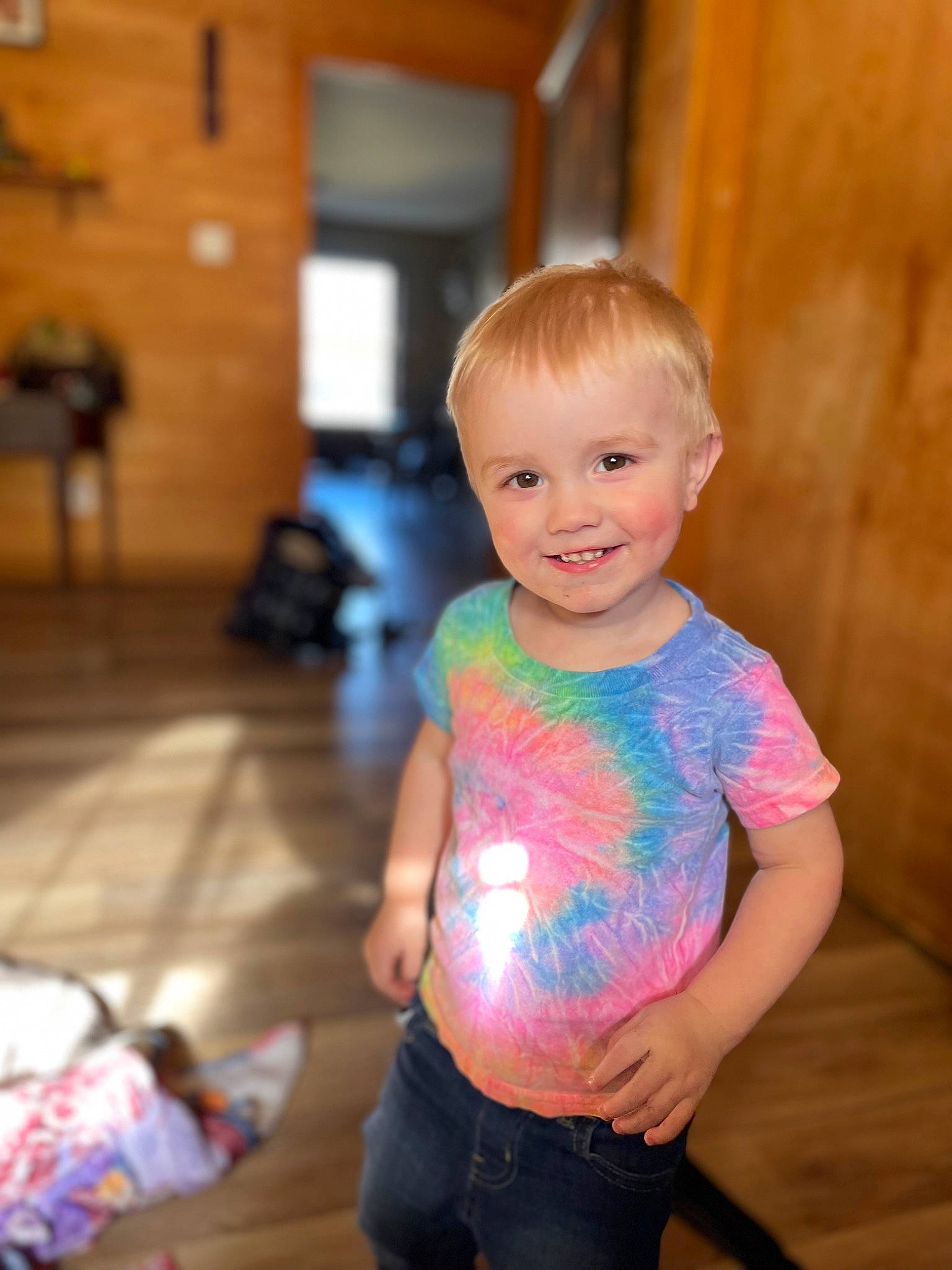 Nova is registered to the contest to win money with this photo: baby_toddler_clothing, blond, child, eye, face, flooring, fun, hair, happy, hardwood, head, iris, joy, person, shoulder, skin, sleeve, smile, standing, t_shirt