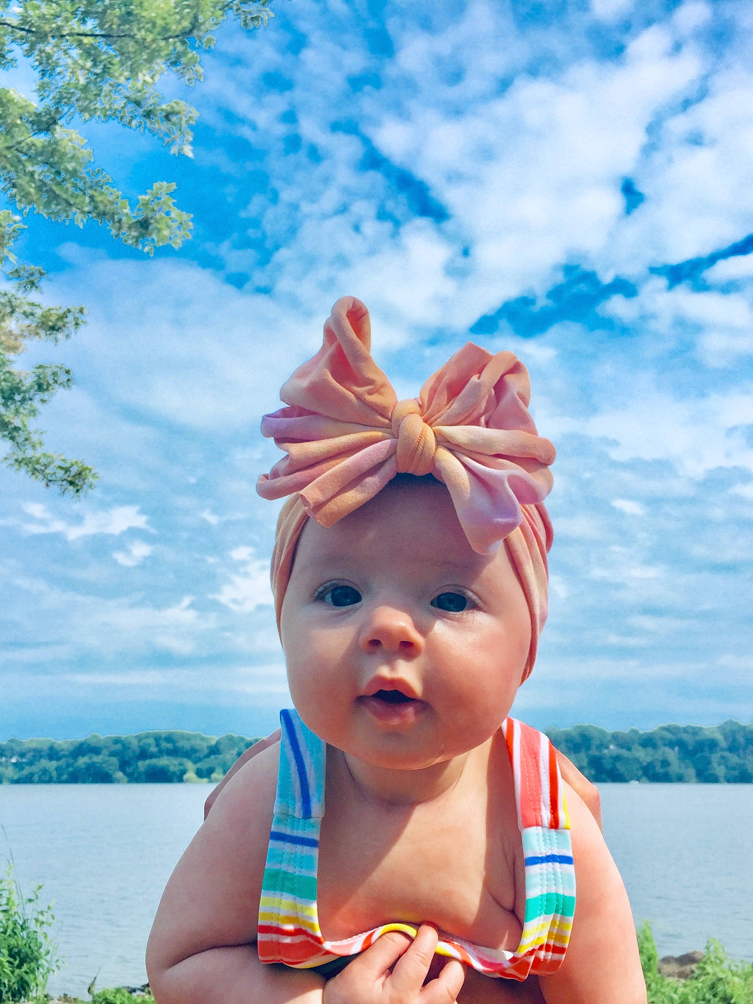 Saoirse is registered to the contest to win money with this photo: baby, child, ear, fashion_accessory, finger, fun, hand, happy, head, headgear, headwear, leisure, neck, organism, person, sky, smile, summer, sunlight, toddler
