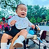 Arya joined the competition — help win amazing prizes! baby, bench, bib, blue_sky, child, clothing, daylight, happy, held, infant, laughing, outdoor, park, playground, portrait, scooter, smiling, socks, swing_set, trees