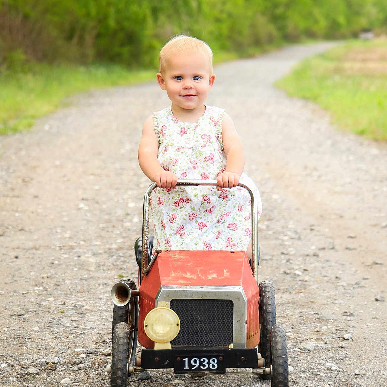 Hannah is registered to the contest to win money with this photo: baby, city, clothing, dress, face, grass, gravel, head, machine, path, person, photography, plant, portrait, road, spoke, street, urban, walking, wheel