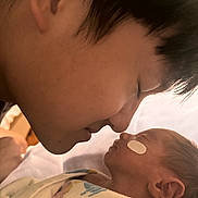 Mia is registered to the contest to win money with this photo: adult, baby, blanket, closeup, face, family, gentle, human, infant, love, newborn, parent, peaceful, portrait, skin, sleeping, tender, touch, wrapping, young