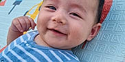 Hady is registered to the contest to win money with this photo: baby, smiling, face, arm, grass, play_mat, blue_clothing, child, happy, outdoor, infant, cute, skin, person, young_child, portrait, lying_down, summer, striped_shirt, baby_boy