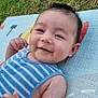baby, smiling, face, arm, grass, play_mat, blue_clothing, child, happy, outdoor, infant, cute, skin, person, young_child, portrait, lying_down, summer, striped_shirt, baby_boy