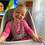 Gabriëlla participe au concours pour gagner de l'argent avec cette photo : baby, bright, child, cute, face, furniture, hand, happy, high_chair, indoor, person, pink_clothing, portrait, room, seatbelt, sitting, smile, table, toddler, young_child