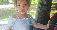 Bri is registered to the contest to win money with this photo: black_pants, car, casual_clothing, child, curious, daylight, hair, indoors, interior, messy_hair, portrait, seat, seatbelt, standing, sunlight, toddler, vehicle, white_top, window, young_child