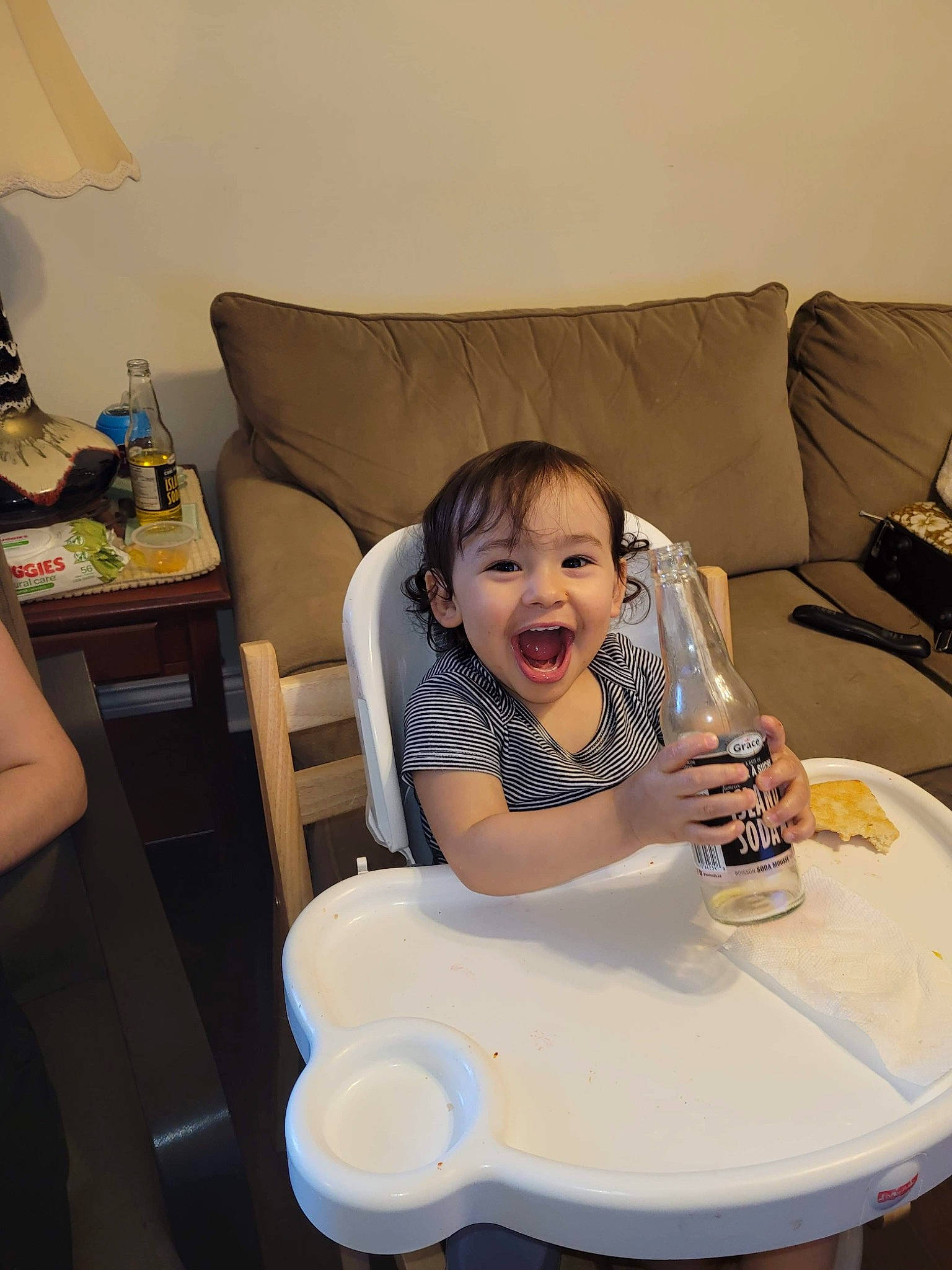 Mateo is registered to the contest to win money with this photo: baby, baby_toddler_clothing, bottle, chair, child, comfort, couch, drinkware, happy, lamp, person, picture_frame, pillow, plastic_bottle, room, sitting, skin, smile, table, thumb