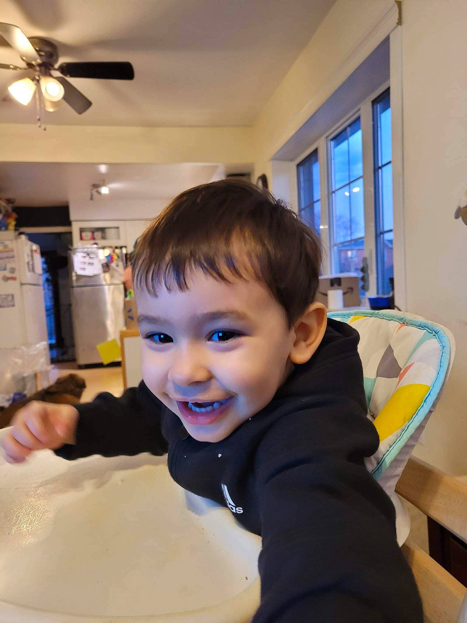 Mateo joined the competition — help win amazing prizes! ceiling, ceiling_fan, chair, child, desk, flooring, fun, happy, home_appliance, joy, mechanical_fan, person, refrigerator, room, sitting, smile, t_shirt, table, television, toddler
