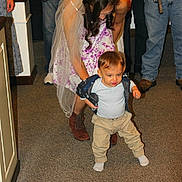 Jason joined the competition — help win amazing prizes! boots, carpet, casual_clothing, celebration, child, family, floral_dress, helping, holding_hands, indoor, jeans, learning_to_walk, people, smiling, socks, support, toddler, veil, walking, woman