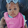 Serenity is registered to the contest to win money with this photo: baby, child, bow, pink_bib, car_interior, steering_wheel, kia_logo, seat, infant, portrait, cute, looking_at_camera, clothing, human, car, dashboard, sitting, young_child, face, expression