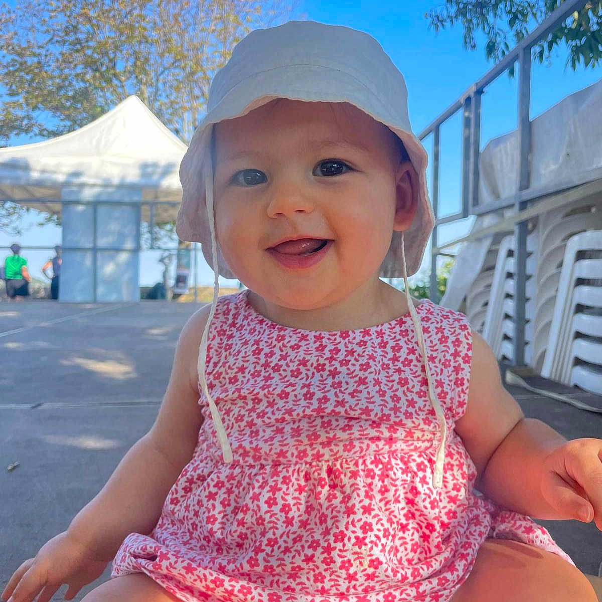 Diane participe au concours pour gagner de l'argent avec cette photo : baby, child, cute, daylight, dress, face, floral_pattern, happy, hat, nature, outdoor, person, pink, playful, sitting, sky, smiling, summer, sunhat, tent