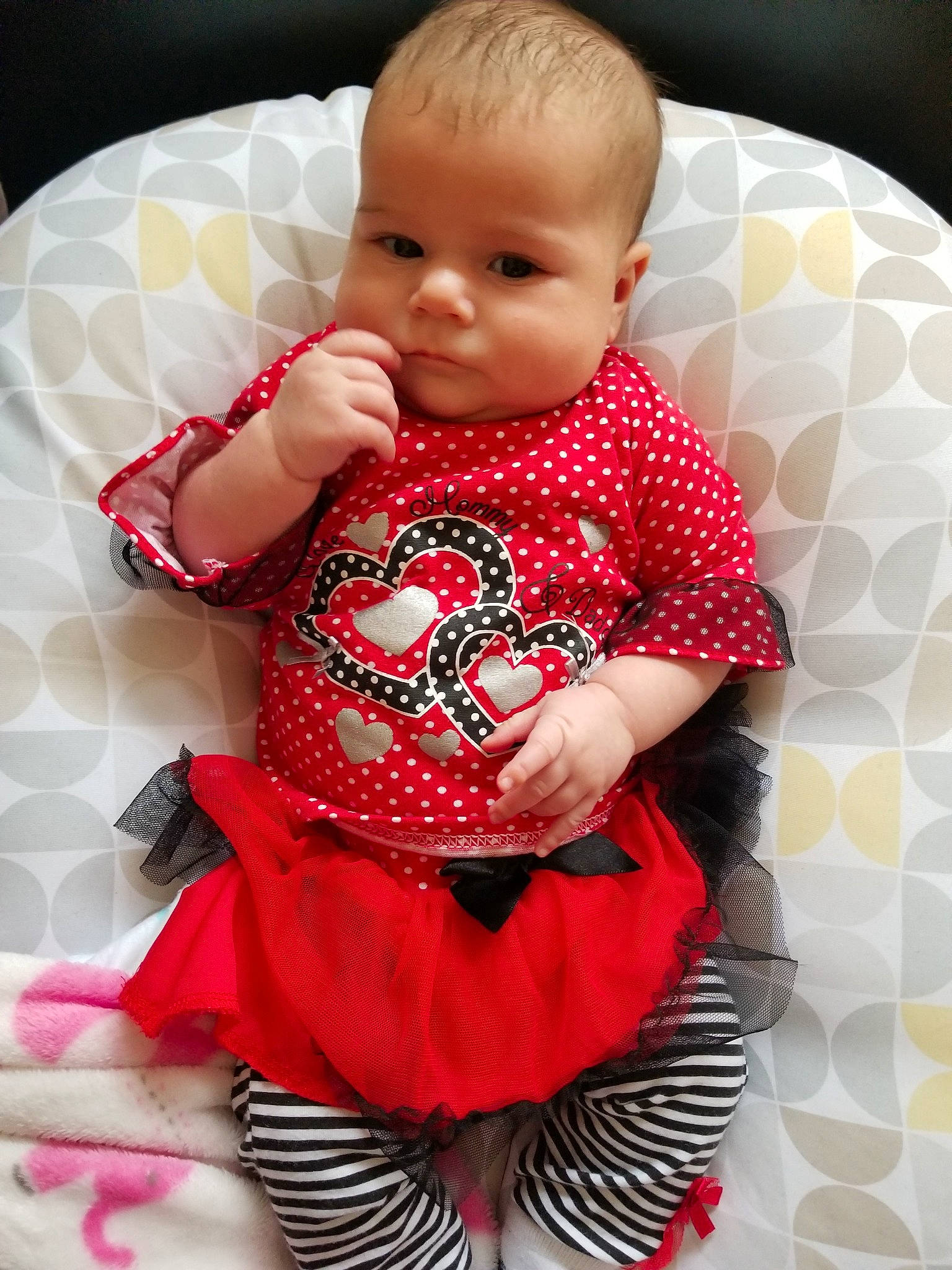 Colette is registered to the contest to win money with this photo: baby, baby_products, baby_toddler_clothing, cheek, child, design, dress, pattern, person, pink, product, red, skin, sleeve, textile, toddler