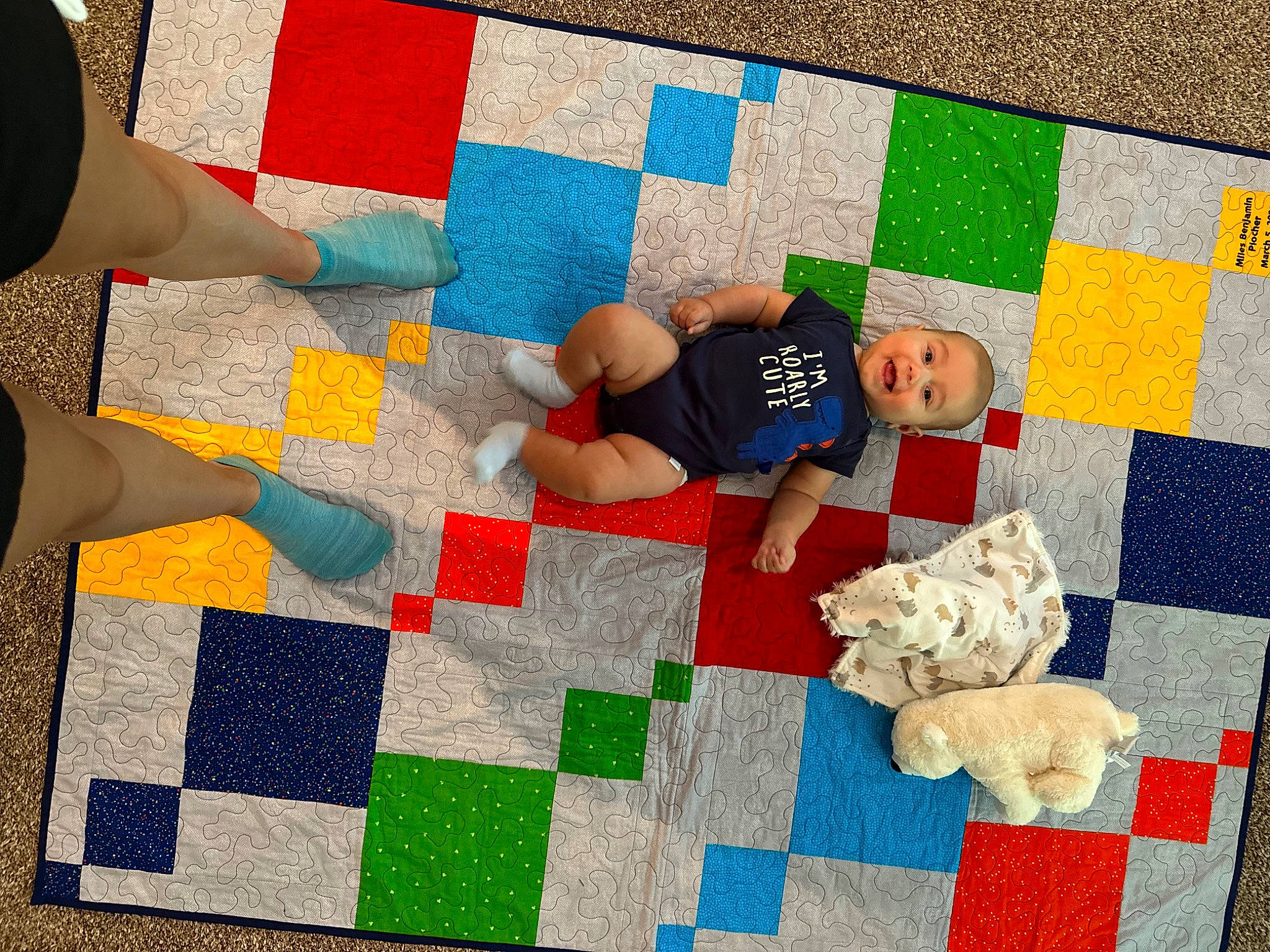 Miles is registered to the contest to win money with this photo: art, baby, carpet, child, comfort, floor, flooring, fun, human_leg, linens, pattern, person, play, playmat, rectangle, red, textile, toddler, toy, wood