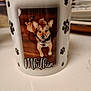 animal, brown_dog, ceramic, close_up, collar, cute, decorative, dog_photo, indoor, mug, name_text, paw_prints, personalized, pet, pet_mug, portrait, still_life, table_surface, white_background, wooden_floor