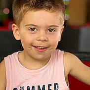 Mario participe au concours pour gagner de l'argent avec cette photo : child, boy, smiling, portrait, short_hair, sleeveless_shirt, dinosaur_graphic, summer, casual_clothing, indoor, blurry_background, happy, young, cute, person, face, head_and_shoulders, light_skin, brown_eyes, closeup